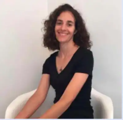 Headshot of Dr. Emily Levine, a thin, white woman with short, dark curly hair